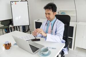 Doctor's Consultation and Professional Analysis. A physician reviews patient data while analyzing reports on a laptop. photo