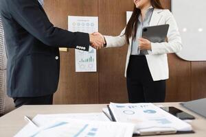 Handshake and Commitment. Business professionals shake hands to seal a successful agreement after a project presentation. photo