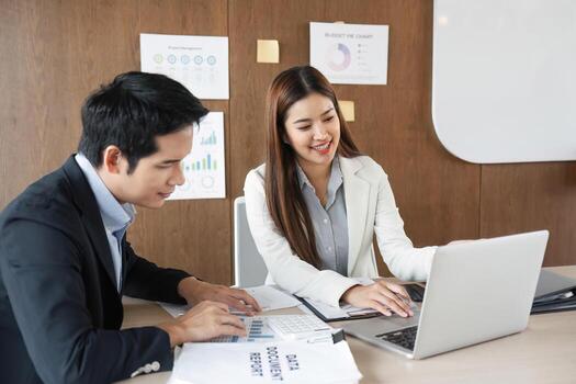 Collaborative Financial Review. Two business professionals reviewing and discussing performance metrics in a modern office setting. photo