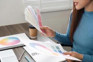 Color Theory and Creative Design. A designer carefully analyzing color palettes to enhance a project. photo