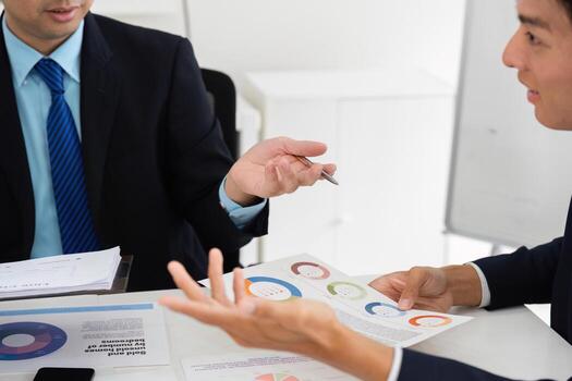 Team Discussion and Data Analysis. Professionals engaged in a collaborative meeting analyzing market data and performance statistics. photo