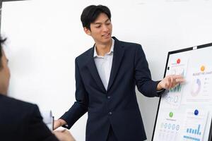 Business Presentation and Analytical Discussion. A young professional presenting financial data to a team. photo