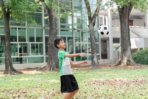 Soccer Skills and Focus. A boy practices his soccer skills by catching a ball in the park. photo