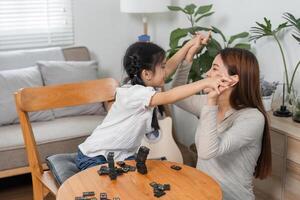 Laughter and Play. A mother and daughter share a playful moment during a game of dominoes. photo