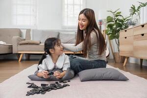 Family Fun and Playtime. A joyful mother and daughter enjoy a playful moment while engaging with dominoes. photo