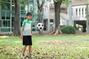 Child Exercise and Soccer Skills. A young boy practices with a soccer ball in the park. photo