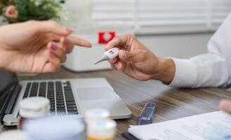 Health Monitoring Discussion. A doctor interacts with a patient about health metrics using a thermometer. photo