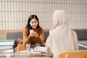 In-Depth Discussion and Study. Two women engaged in focused conversation over study materials. photo