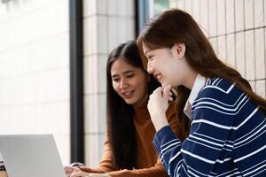 Digital Learning and Collaboration. Two students enjoy digital resources while studying together at a cafe. photo