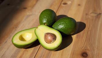 Fresh Avocados on Wooden Surface with One Halved photo
