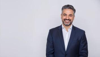 Professional man in a suit smiling confidently against a neutral background photo