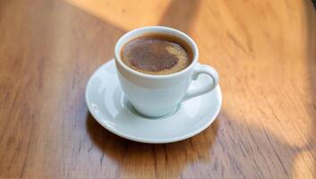 Aromatic Fresh Brewed Coffee in a White Cup on a Wooden Table photo