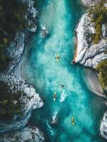 Aerial View of Turquoise River with Kayaks Surrounded by White Rocks and Green Trees on Sunny Day photo