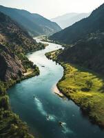 Aerial View of Kayaks in Blue River Meandering Through Green Valley Surrounded by Mountains Under Bright Sunlight photo