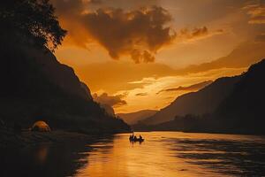 Golden Sunset Reflected On Wavy River with Silhouette Mountain Range and People in Canoe Under Cloudy Orange Sky photo