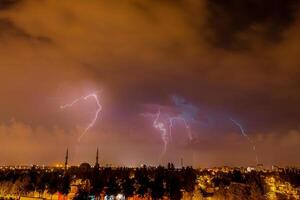 Lightning discharges in the night sky during a thunderstorm. Large thundercloud and lightning discharges. photo