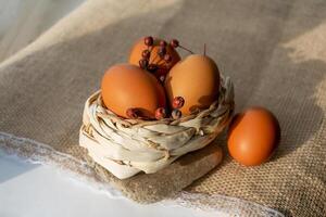 Brown eggs in a basket on a background of burlap photo