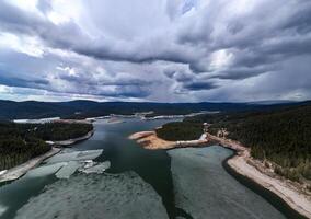 Melting Ice Floes on a Mountain Lake Under Storm Clouds photo