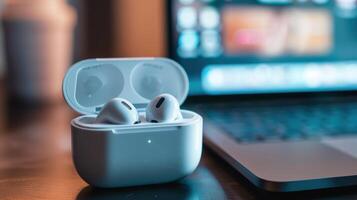 Wireless Earbuds in Charging Case with Laptop Background for Modern Technology Themes photo