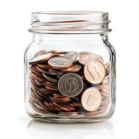 A clear glass jar filled with assorted coins isolated on a white background, representing savings and financial planning. photo