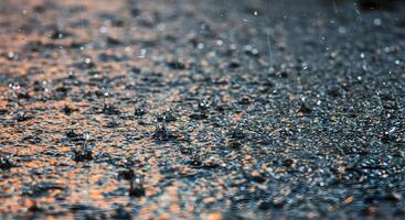 Water droplets landing on a rough, textured surface, forming dynamic ripples and tiny streams, suitable for environmental and documentary content. photo