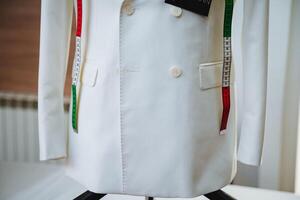 A pristine white coat elegantly displayed on a mannequin, adorned with a measuring tape, serves to emphasize the crucial significance of precise measurements in the world of fashion design photo