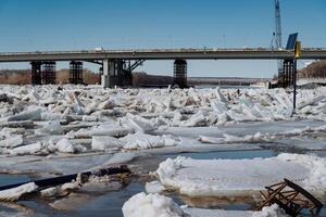 In the background, there stands a bridge, and you can also see an abundance of ice floating on the water, creating a beautiful winter scene that captures the essence of the season photo