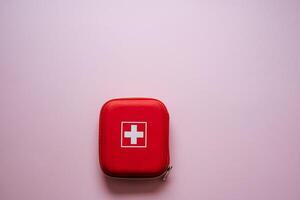 This Compact Red First Aid Kit features a White Cross on a Pink Background, perfect for your healthcare needs and ensuring youre always prepared for any situation photo