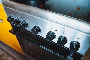 This image features a closeup view of a stove, with a vibrant yellow cabinet visible in the background, enhancing the kitchens overall look and feel, making it more inviting photo