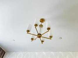 A stunning chandelier beautifully hangs from the ceiling, serving as a captivating focal point that truly enhances the rooms unique charm and elegance, drawing the eye of every observer photo