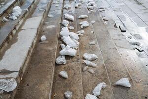 A collection of various rocks is scattered across the surface of a set of stairs, creating an uneven and rugged appearance that can be both natural and visually interesting photo
