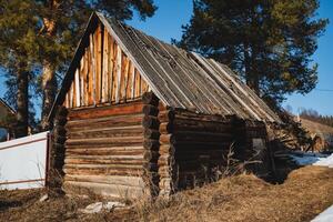 Nestled in the expansive heart of a vast, open field, there stands a quaint and charming, small wooden house characterized by a sturdy roof that adds significantly to its rustic appeal photo