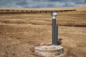In the center of a wide, expansive open field stands a solitary pole, and towering in the background is a bridge that elegantly spans the distance, creating a truly striking visual scene photo