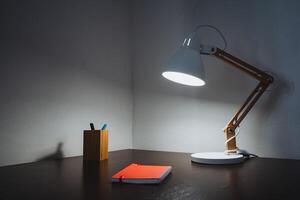 A stunningly crafted wooden desk paired with a stylish lamp illuminating an open notebook creates a warm and inviting workspace that truly fosters and encourages a flow of creativity photo