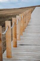Wooden posts are aligned in a straight row, with strong ropes tied to each, creating a clear boundary that enhances safety and organization, making the area more accessible and efficient photo
