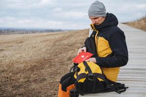 Exploring the Wonders of Nature An Adventurer Pausing to Carefully Organize Their Gear While on the Beautiful Trail Through the Scenic Woods and Majestic Mountains photo