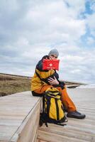 An adventurous hiker is equipped with a backpack and a first aid kit, enjoying the serene beauty of a natural landscape while seeking thrilling exploration opportunities photo