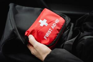 A person confidently holds a comprehensive, wellstocked first aid kit, prepared and ready to respond promptly to any medical emergencies that may arise, demonstrating ease and skill photo