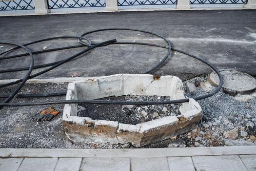 A unique and distinct hole in the ground can be seen, with numerous wires extending outwards in a variety of directions, suggesting an entangled and complex setup or structure photo