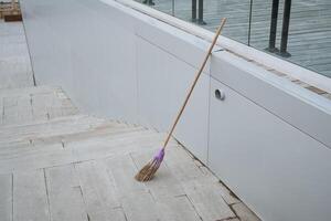 On a tiled floor, there is a broom that features a striking purple handle, making it a colorful addition to the household cleaning supplies that can be found in any home photo
