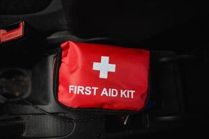 In case of emergencies while driving, there is a red first aid kit prominently displayed, featuring a large white cross, making it easily recognizable and readily accessible for quick help photo