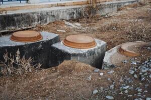 A group of concrete septic tanks is sitting in the dirt, waiting for installation. These tanks serve as an essential building material for waste management in various constructions photo