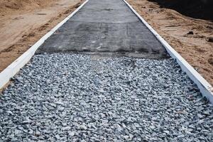 A new road is currently being constructed, and it will be made using a combination of gravel and asphalt as the primary materials to create an effective and durable surface photo