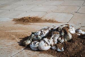 Piles of Waste Addressing the pressing environmental concerns that arise due to the accumulation of sandbags and soil on urban pavement surfaces in our cities today photo
