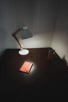 A lamp emits a warm and inviting light on the nearby desk, which features an open notebook prepared for jotting down notes, thereby fostering a truly wonderfully productive atmosphere photo