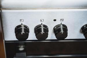 This image shows a closeup of a sleek, modern stove with four front knobs for efficient control over heating elements and cooking functions, enhancing your culinary experience photo