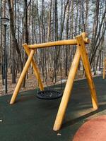 Experience a Unique Wooden Swing set in a Serene Forest Playground, perfect for adventure, relaxation, and mindfulness surrounded by lush greenery and beautiful landscaping photo