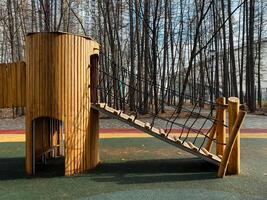 Introducing a Unique Wooden Playground Structure featuring a Climbing Rope, all set in a Serene Natural Setting. A perfect place for children to enjoy playtime and adventure photo
