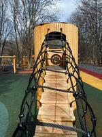 Discover a Unique Wooden Playground Structure featuring an exciting Rope Bridge and various Climbing Features, designed specifically for Children to enjoy Outdoor Fun photo