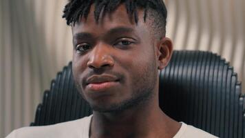 Portrait face futuristic confident serious gamer programmer calm African American man guy male in futurism modern white room studio looking at camera blinking eye flirting blink innovation technology photo